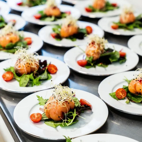 Plates of gourmet sashimi salad with fresh vegetables and sprouts ready for serving.