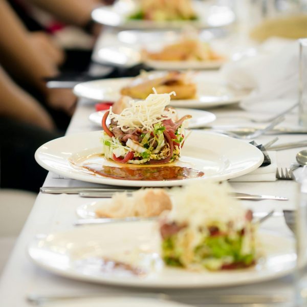 Long dining table set with gourmet salads, perfect for a fine dining experience.
